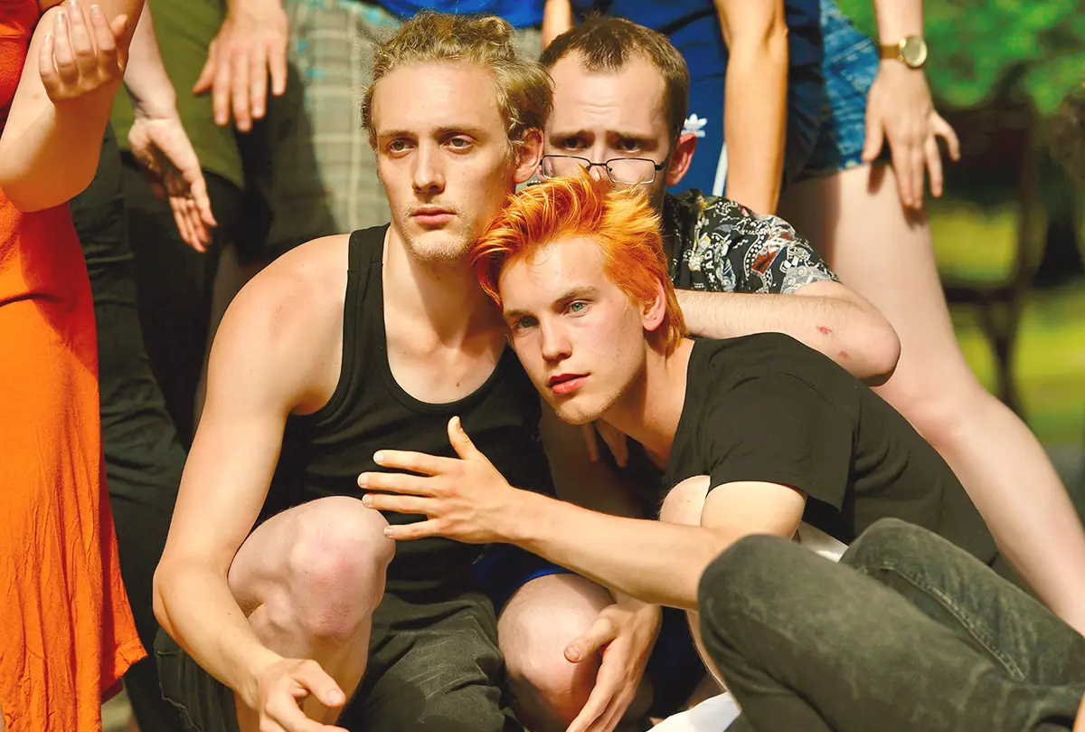 Zwei junge Schauspieler der Sommerakademie in einer nahen, ausdrucksstarken Ensembleszene im Freien