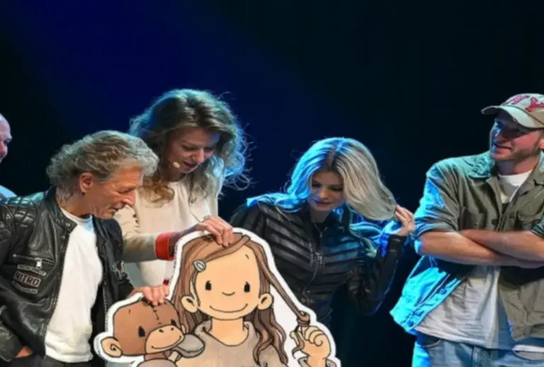 Bühnenszene aus dem Kindermusical Anouk: Mehrere Personen halten eine große Pappfigur des Anouk-Mädchens mit einem Äffchen.