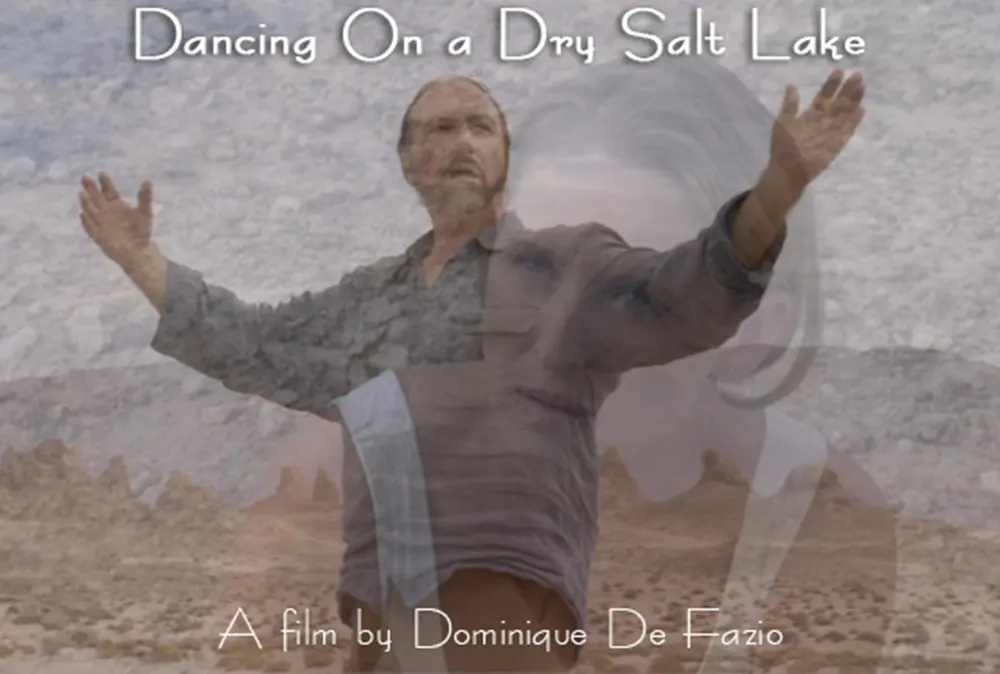 Filmpostkarte zu Dancing on a Dry Salt Lake, ein Mann mit weit ausgebreiteten Armen in einer Wüstenlandschaft, überlagert von einem Frauengesicht