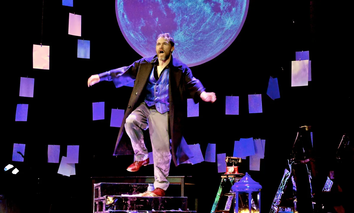 Johannes Raatz als Iwan Besdomny auf der Bühne vor der Papierwand und dem Vollmond