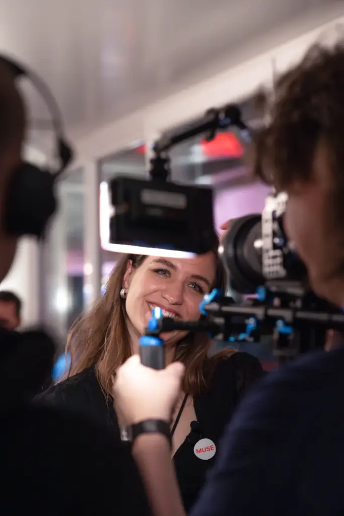 Lächelnde Schauspielerin hinter einer Filmkamera