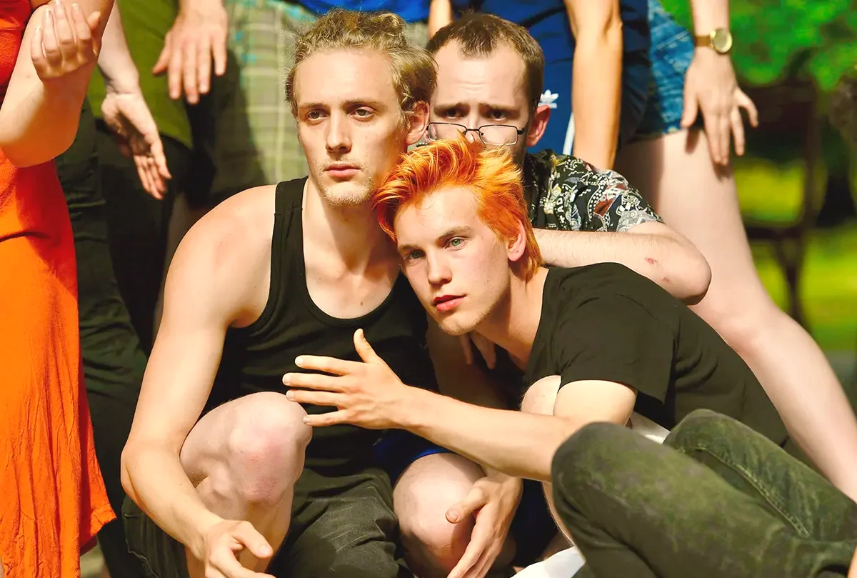 Zwei junge Schauspieler der Sommerakademie in einer nahen, ausdrucksstarken Ensembleszene im Freien